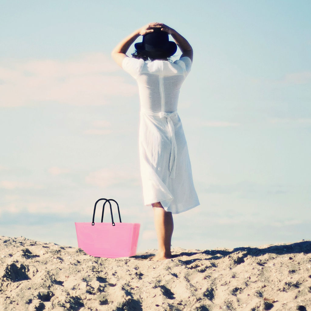 Kvinde på strand med taske